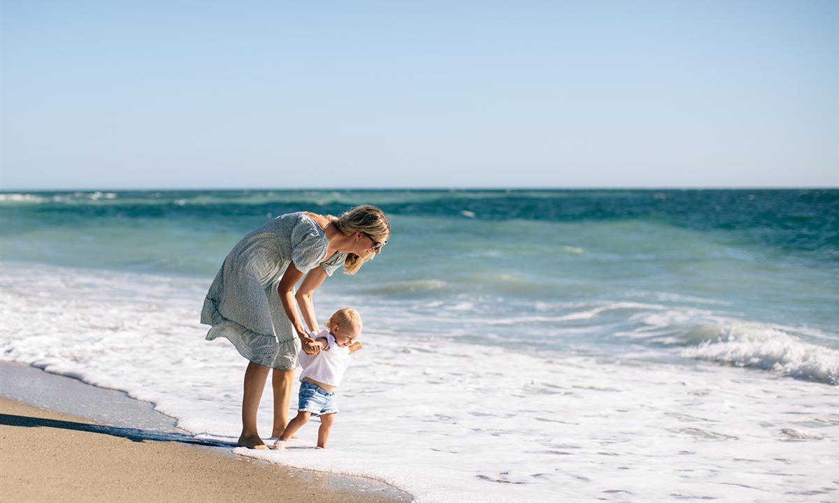 woman and child playing on the beach