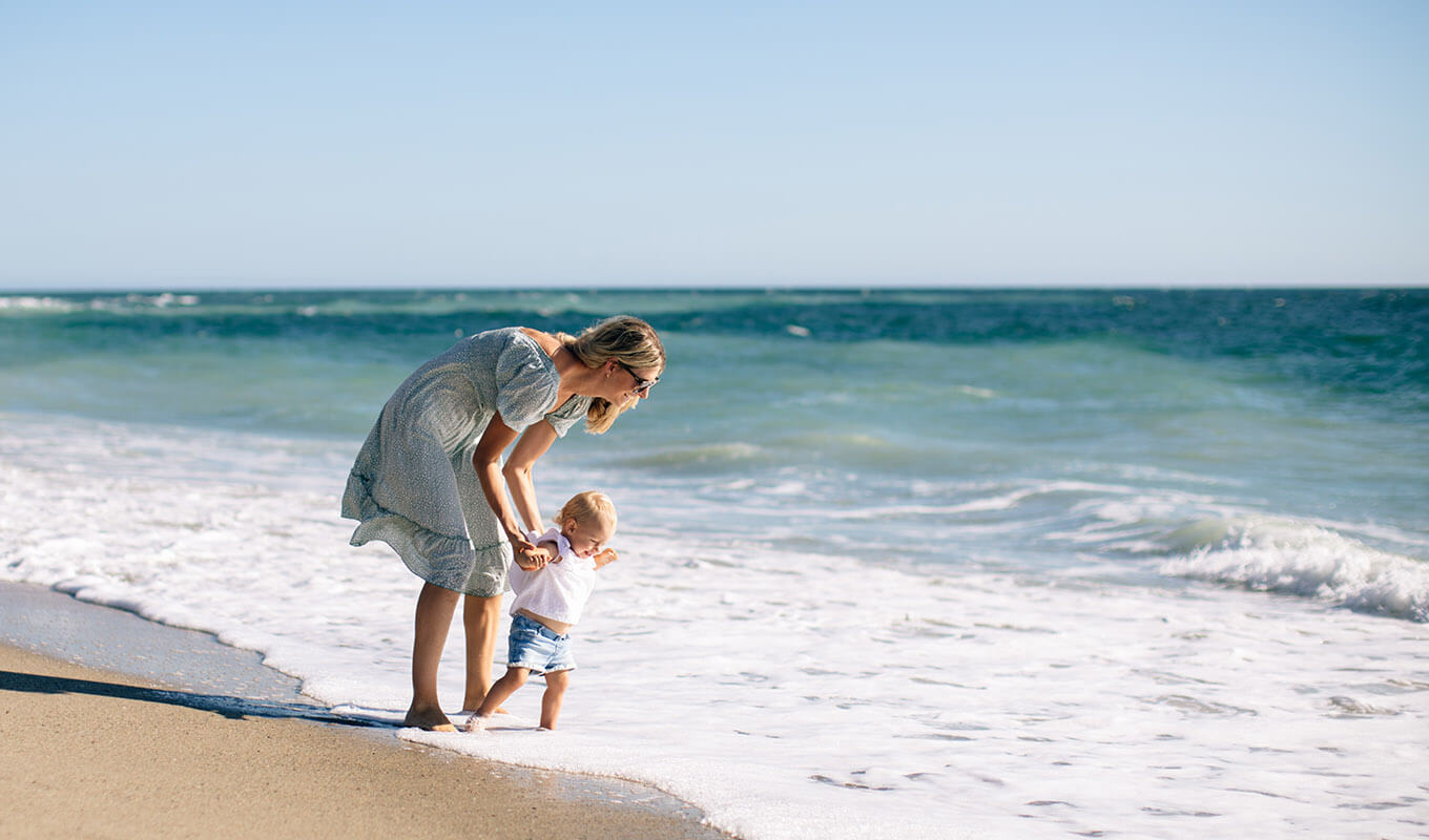 Mother playing with child in the waves of the ocean