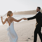 A bride and groom dancing on the beach