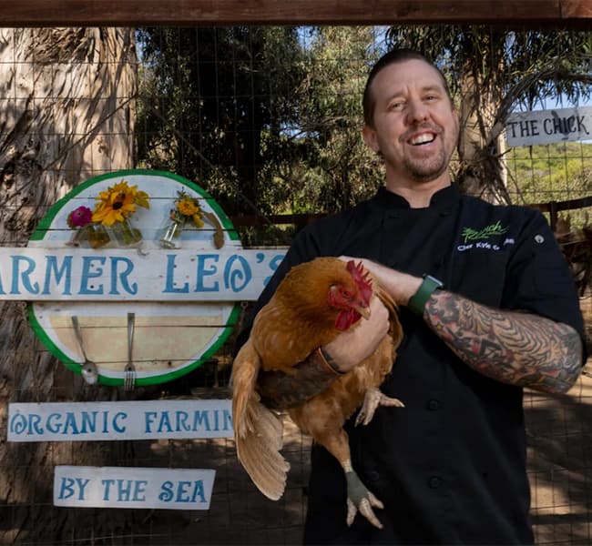 A chef holding a hen