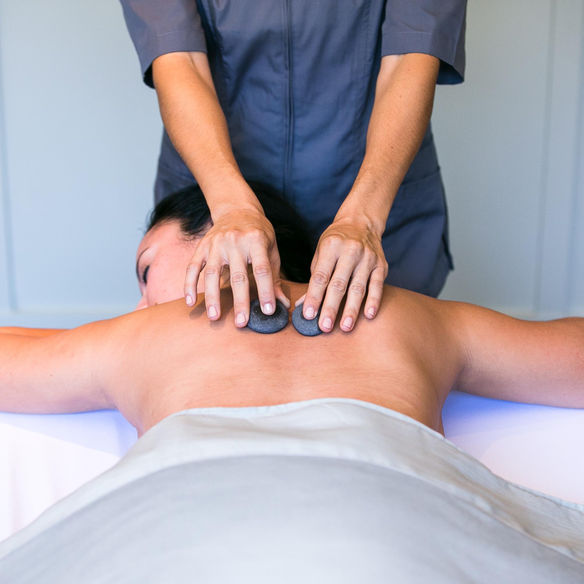 Guest in spa hot stone massage treatment